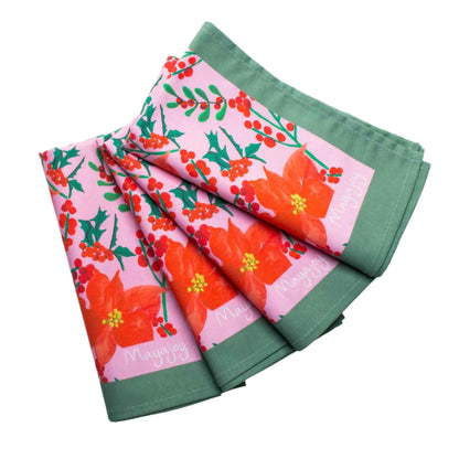 Mayajoy Christmas poinsettia colourful cotton napkins with pink background, hand illustrated red poinsettia and foliage, with sage green trim, styled as stack of 4 napkins. 