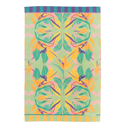 Flat lay colourful cotton tea towel in paradise print, featuring orange and yellow bird of paradise flower with green, pink and purple with stripy edging and hanging loop, by Mayajoy 